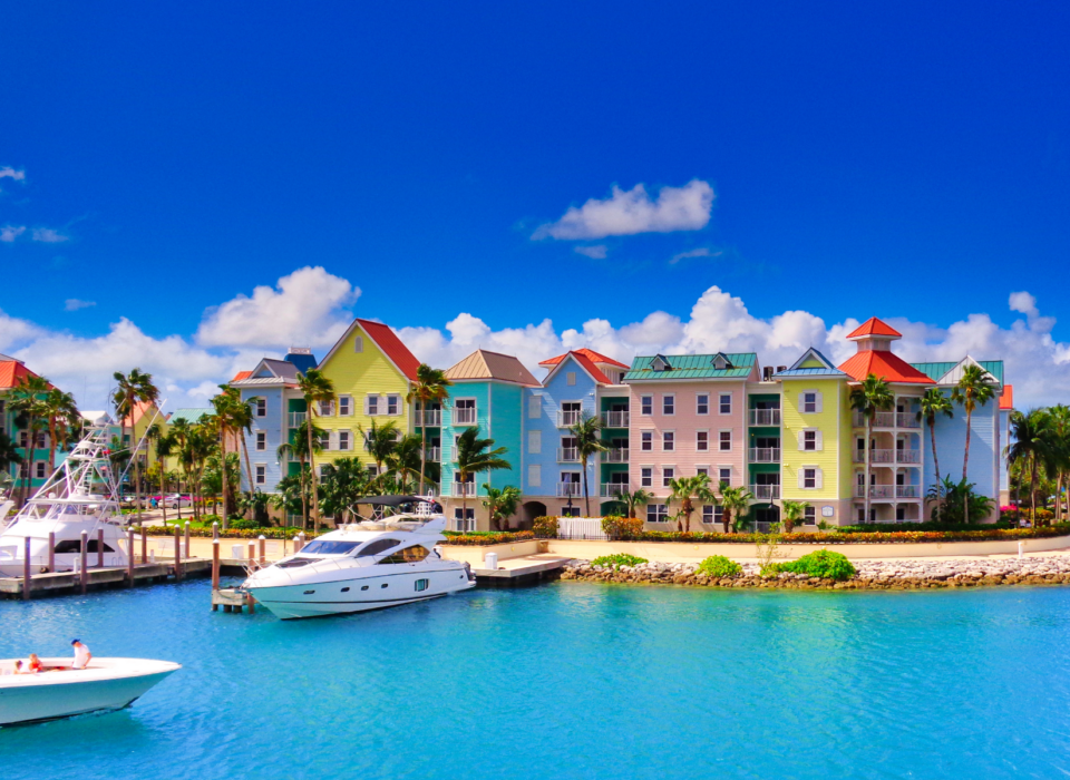 Colorful waterfront buildings in Nassau, Bahamas with boats docked on a sunny day.