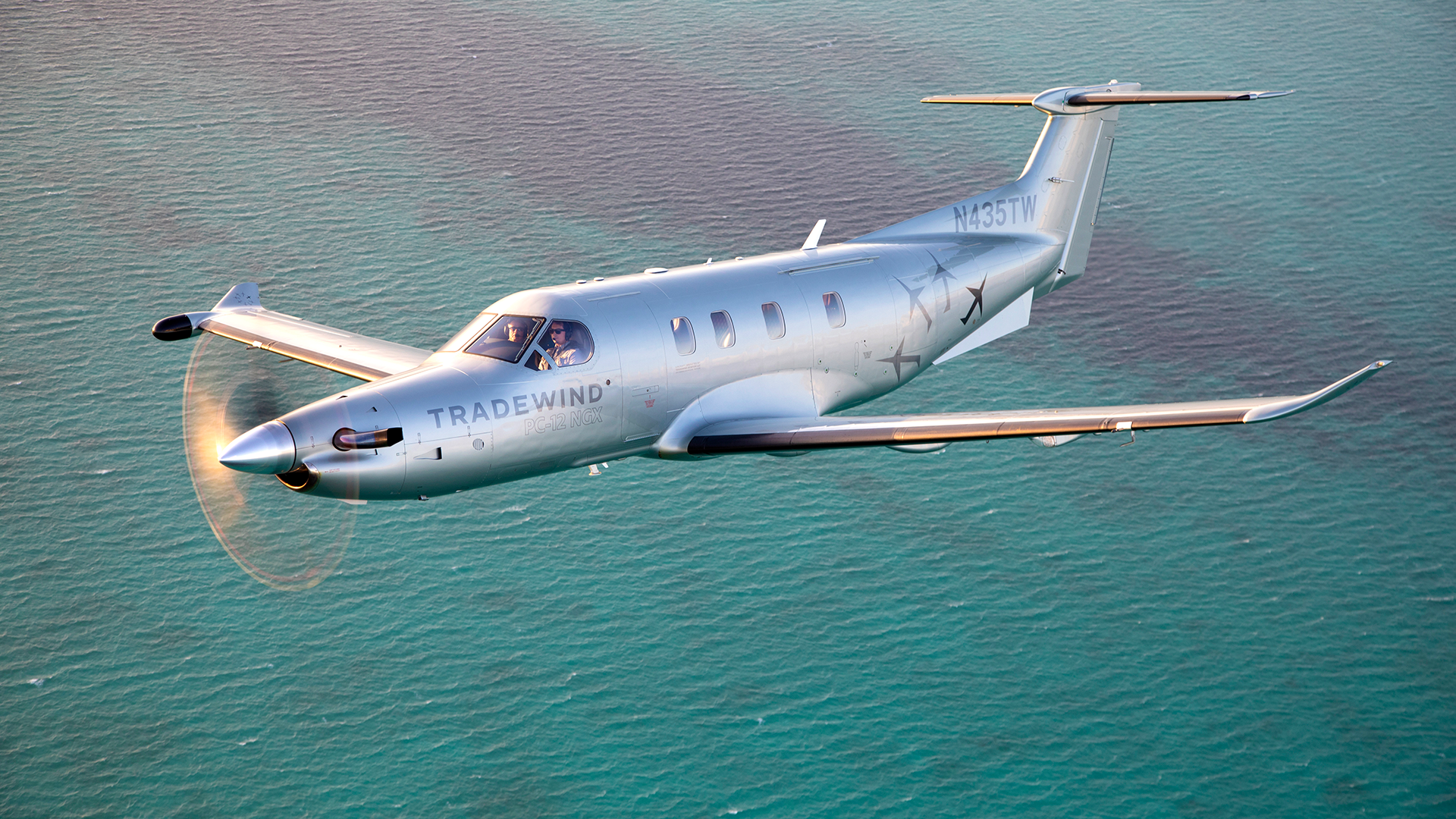 A Tradewind Pilatus plane flying to Nassau over blue water