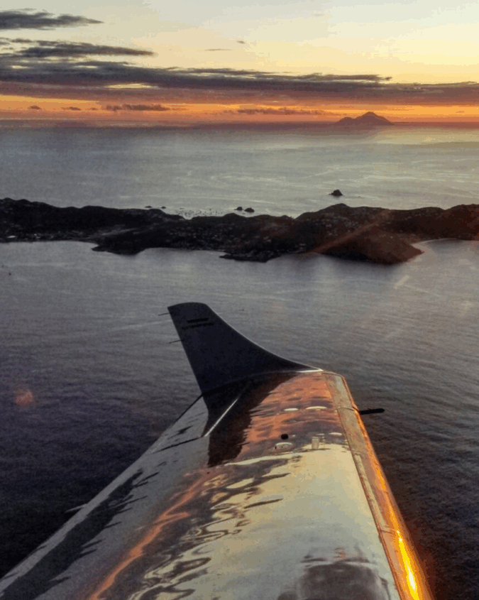 Plane wing views of San Juan islands in the Caribbean at sunset.