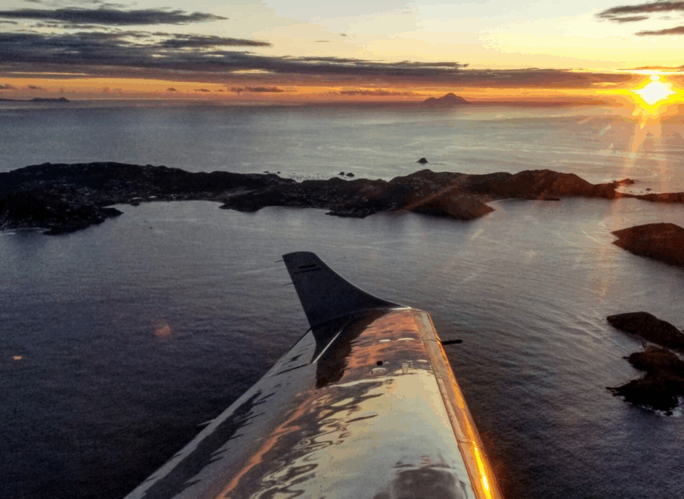 Plane wing views of San Juan islands in the Caribbean at sunset.