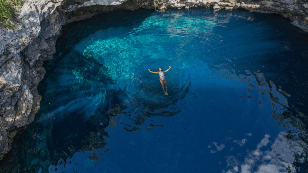 A woman floating in Blue Sapphire Hole in Eleuthera.