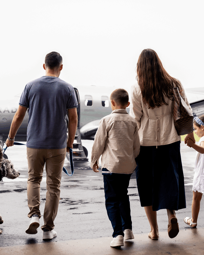 A family with their dog walking towards a Tradewind plane for flights to Nantucket.