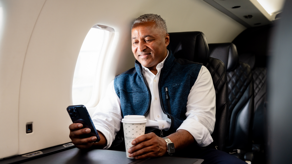 A business traveler checking his phone while on a private charter